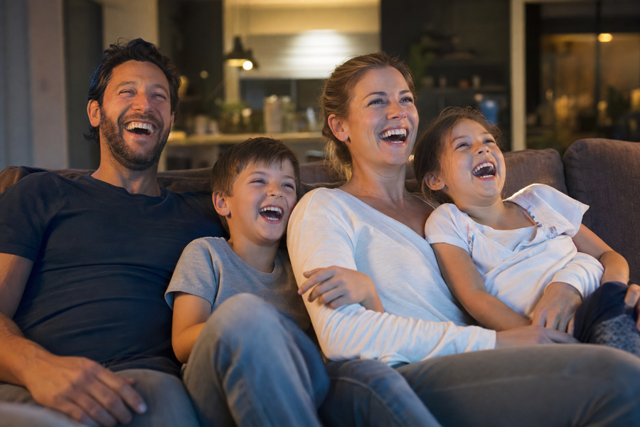Familia entera riendo a carcajadas viendo la tele